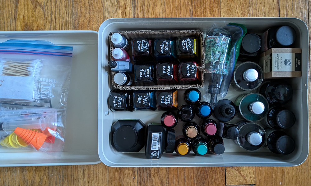 A storage container alomost full of ink bottles